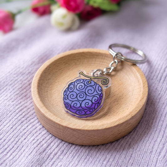 One Piece Gomu Gomu no Mi Devil Fruit anime keychain resting in a small wooden decorative bowl