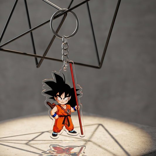 Dragon Ball Kid Goku acrylic keychain hanging from a black wireframe casting a shadow on a concrete display block
