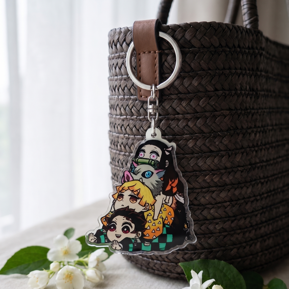 Cute Kimetsu no Yaiba anime keychain attached to a woven tote bag strap surrounded by white flowers